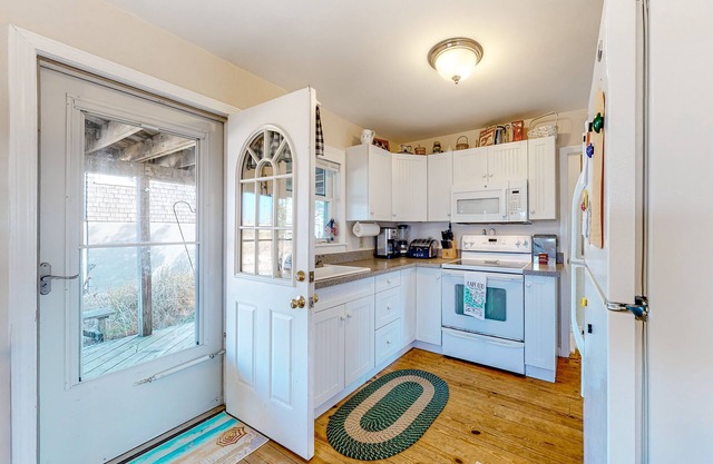 Dog-friendly bay view cottage with a furnished porch, washer/dryer, & roof deck