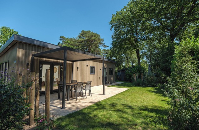 Enjoy a luxurious holiday home for 4 people in the wooded nature of the Veluwe, complete with modern amenities, air conditioning, and a stylish pergola for optimal comfort. Additionally, unwind in the private hot tub, perfect for relaxing after a day